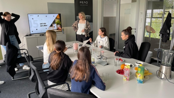 Girls'Day-Teilnehmerinnen an einem Konferenztisch schauen Präsentationen an